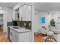 Bright kitchen with white cabinets, gold hardware, and an adjacent sitting area at 7615 E Quincy Ave # 103, Denver, CO 80237