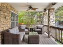 Relaxing covered porch with comfortable seating, ceiling fan, and stone detailing, perfect for outdoor enjoyment at 7836 S Fairfax Ct, Centennial, CO 80122