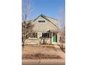 Light green two-story home showcasing a front yard with a walkway leading to a green front door at 3640 Elm St, Denver, CO 80207