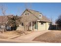 Light green two-story home featuring brick and vinyl siding and a driveway leading up to the house at 3640 Elm St, Denver, CO 80207