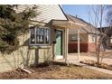 Charming brick home featuring a covered front porch with a green front door and a bright window at 3640 Elm St, Denver, CO 80207