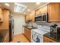 Well-lit kitchen featuring stainless steel appliances, granite countertops, and light wood cabinets at 12151 Melody Dr # 202, Westminster, CO 80234