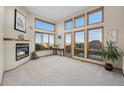 Bright living room with a cozy fireplace and large windows offering panoramic views at 10592 Raven Run, Littleton, CO 80125