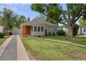 A charming single-story home with a gray exterior, well-maintained lawn, and a detached garage at 2709 S Franklin St, Denver, CO 80210