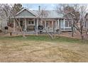 Spacious backyard featuring a covered patio, mature trees, and well-maintained landscaping at 87 Canongate Ln, Highlands Ranch, CO 80130