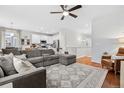 Open-concept living area with a comfortable sectional, hardwood floors, and access to the kitchen at 25148 E Lake Pl, Aurora, CO 80016