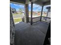 View from covered porch of neighborhood with stone supports and dark railings at 394 Grey Rock St, Brighton, CO 80601