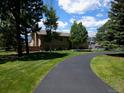 Spacious, two-story home with a long driveway and mature trees at 1095 Lake Woodmoor Dr, Monument, CO 80132