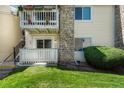 Exterior corner of a condo featuring a balcony with stone accents and manicured greenery at 8555 Fairmount Dr # G103, Denver, CO 80247