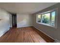 Bright living room featuring hardwood floors and a large bay window with natural light and outdoor views at 2991 S Whiting Way, Denver, CO 80231