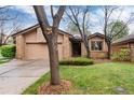 Charming brick home with mature landscaping, a lawn, and an attached garage at 7500 E Dartmouth Ave # 16, Denver, CO 80231
