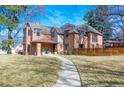Stately brick residence with gabled rooflines, mature trees, and a stone walkway leading to the front entrance at 290 Dexter St, Denver, CO 80220
