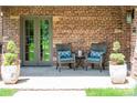 Inviting front porch with brick facade, seating, and elegant double door entrance at 290 Dexter St, Denver, CO 80220