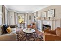 Cozy living room with a fireplace, bay window, hardwood floors, and stylish furnishings at 290 Dexter St, Denver, CO 80220