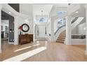Grand foyer with soaring ceilings, hardwood floors, a curved staircase, and ample natural light at 4915 S Vine St, Cherry Hills Village, CO 80113