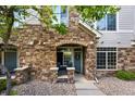 Inviting townhome entrance featuring a stone archway, front porch, and cozy outdoor seating at 494 Black Feather Loop # 108, Castle Rock, CO 80104