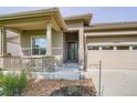 Charming home exterior with stone accents, a covered porch, and a two-car garage at 15852 Lavender Pl, Broomfield, CO 80023
