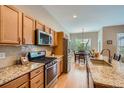 Modern kitchen with granite countertops, stainless steel appliances, and hardwood floors at 15852 Lavender Pl, Broomfield, CO 80023