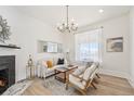 Bright living room with a decorative fireplace, chandelier lighting, and hardwood floors creating an inviting space at 300 Inca St # A, Denver, CO 80223