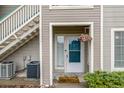 Charming entryway with a teal door, hanging flowers, and exterior stairs to upper units at 8465 Pebble Creek Way # 102, Highlands Ranch, CO 80126