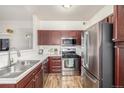 Efficient kitchen with stainless steel appliances, wood cabinets, and a bright, clean aesthetic at 8465 Pebble Creek Way # 102, Highlands Ranch, CO 80126