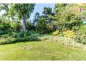 Expansive grassy backyard framed by a variety of lush trees, bushes and flowering plants at 8888 W 37Th Pl, Wheat Ridge, CO 80033