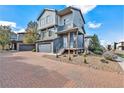 Two-story home with gray siding and a paved driveway at 4849 Halifax Ct, Denver, CO 80249