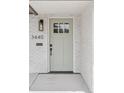 Inviting front door with sage-green finish, sleek black hardware, and brick surround at 3440 N Harrison St, Denver, CO 80205