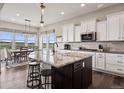 Well-lit kitchen featuring granite counters, stainless appliances, and dining area with scenic views at 8621 S De Gaulle Ct, Aurora, CO 80016