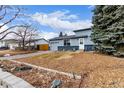 A well-maintained two-story home sits on a spacious lot with mature trees and landscaping at 3089 S Winston St, Aurora, CO 80013