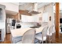 The stunning kitchen features an island with seating, white cabinets, and stainless steel appliances at 1501 Wazee St # 4B, Denver, CO 80202