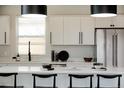 Modern white kitchen with sleek countertops, stainless steel appliances, and pendant lighting at 7918 Raleigh Pl, Westminster, CO 80030