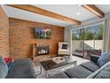 Bright living room featuring a brick fireplace and access to outdoor patio at 9675 E Kansas Cir # 45, Denver, CO 80247