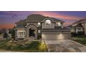 Charming two-story home featuring a three-car garage, brick accents, and a beautifully landscaped front yard at 6911 Chestnut Ct, Parker, CO 80134