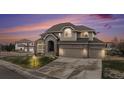Beautifully landscaped two-story home featuring a three-car garage, and a manicured lawn at 6911 Chestnut Ct, Parker, CO 80134