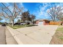 Brick home exterior showcasing a large driveway, attached garage, and well-kept landscaping at 3022 Blackhawk St, Aurora, CO 80011