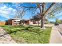 Attractive brick home with a lush green lawn, mature trees, and a welcoming front entry at 3022 Blackhawk St, Aurora, CO 80011