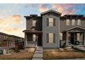 Two-story home with a welcoming front porch, neutral-tone siding, and stylish shutters at 21210 E Radcliff Pl, Aurora, CO 80015