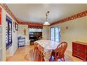 Bright dining area with laminate floors, a pendant light, and a sliding door to the outside at 6971 S Valentia St, Centennial, CO 80112