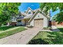 Charming home featuring dormer windows, a well-kept lawn, and an attached one-car garage at 6971 S Valentia St, Centennial, CO 80112