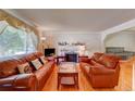 Cozy living room with hardwood floors, a decorative fireplace, and comfortable leather seating at 6971 S Valentia St, Centennial, CO 80112