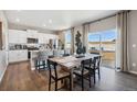 Open-concept kitchen and dining area with stainless steel appliances, a center island, and hardwood floors at 4853 Cattle Cross Ln, Castle Rock, CO 80104