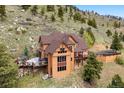 Stunning home with a wraparound deck that integrates seamlessly with the hillside and offers beautiful outdoor living at 33095 Bergen Mountain Rd, Evergreen, CO 80439