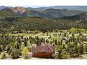 Aerial view of home featuring mountain views and natural surroundings with mature trees at 33095 Bergen Mountain Rd, Evergreen, CO 80439