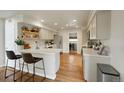 Modern kitchen featuring white cabinets, stainless steel appliances, and hardwood floors with counter seating at 20000 Mitchell Pl # 9, Denver, CO 80249