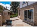 Private outdoor patio with brick accents, sliding glass door, and seating area at 16301 E Ida Ave, Centennial, CO 80015