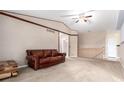 Spacious living room with carpeted floors, a ceiling fan, and a rustic brown leather sofa at 1015 S Fulton Ave, Fort Lupton, CO 80621