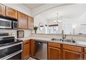 Modern kitchen with stainless steel appliances and wood cabinets at 1385 S Chambers Rd # 104, Aurora, CO 80017