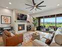 A cozy living room featuring a stone fireplace, modern fan, and a great view of the outdoor patio at 2113 Fountain Cir, Erie, CO 80516