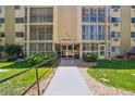 Inviting entrance to a multi-story condo building with lush landscaping and walkway at 13626 E Bates Ave # 110, Aurora, CO 80014